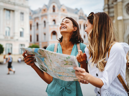 Two girls looking at a map for direction in a European city
