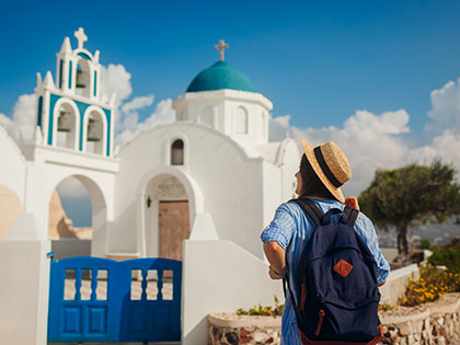 Santorini island traveller visiting a church in Akrotiri, Greece. 